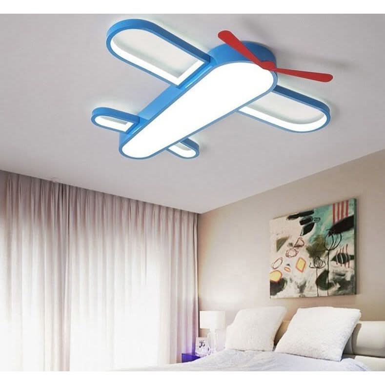 Photo de face du plafonnier avion bleu, ailes et hélice rouges, au-dessus d'un lit