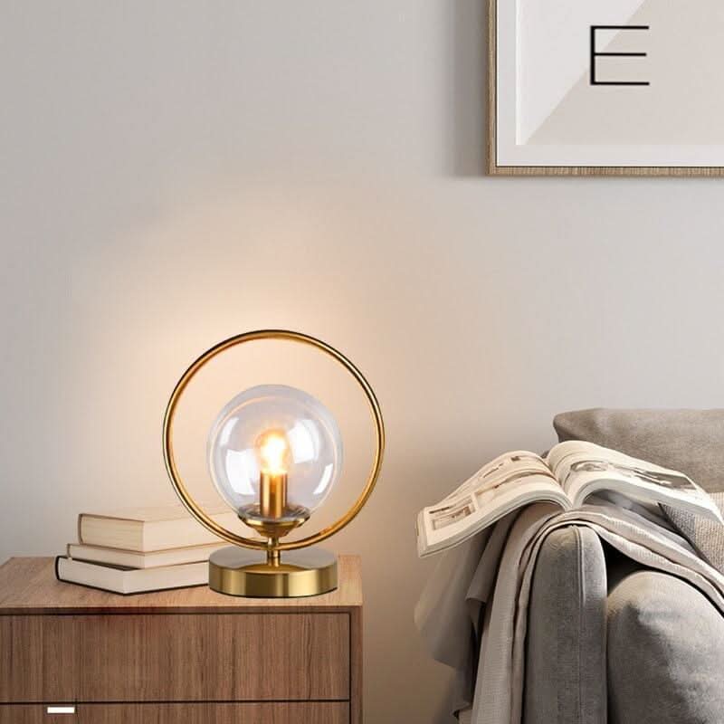 Petite lampe dorée sur une commode en bois auprès de livres empilés