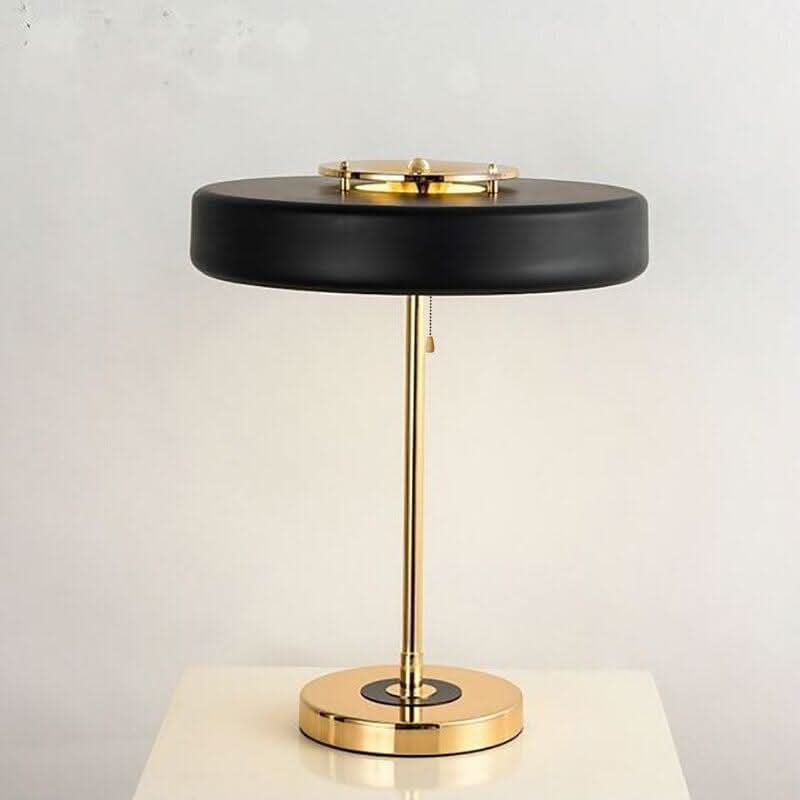 Version noire mate de face, tige et socle en laiton poli sur fond clair