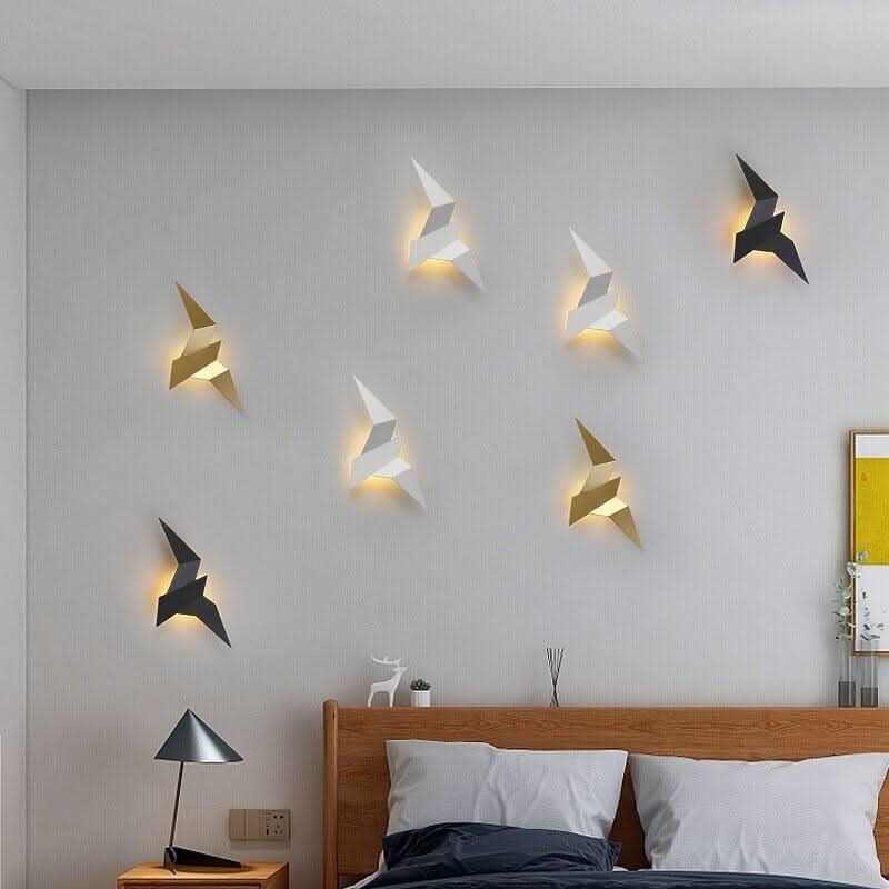Ambiance chambre avec sept appliques murales oiseau disposées en nuée au-dessus du lit