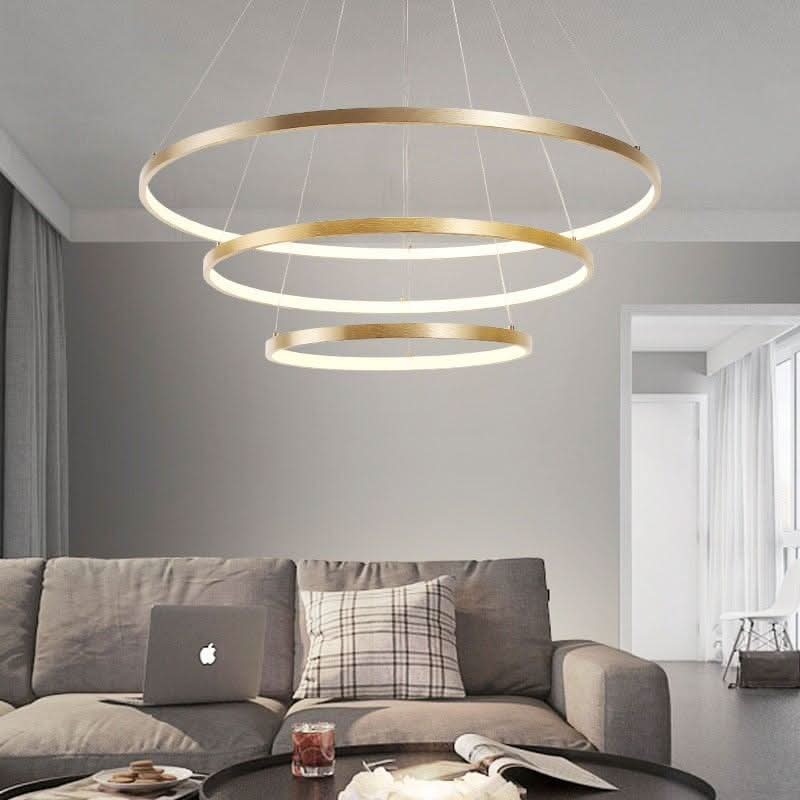 Mise en ambiance du lustre doré à anneaux au-dessus d'un canapé gris