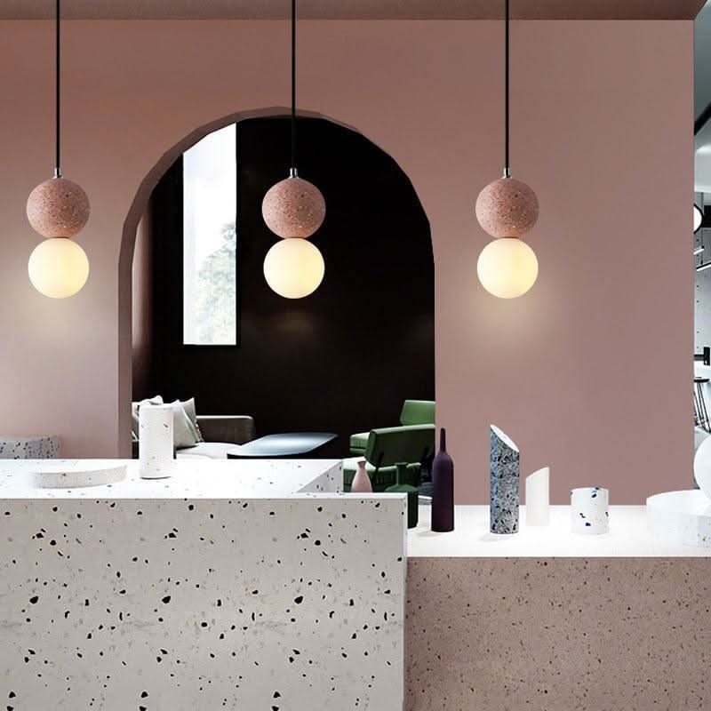 Trois suspensions roses suspendues devant une arche, décor contemporain en terrazzo