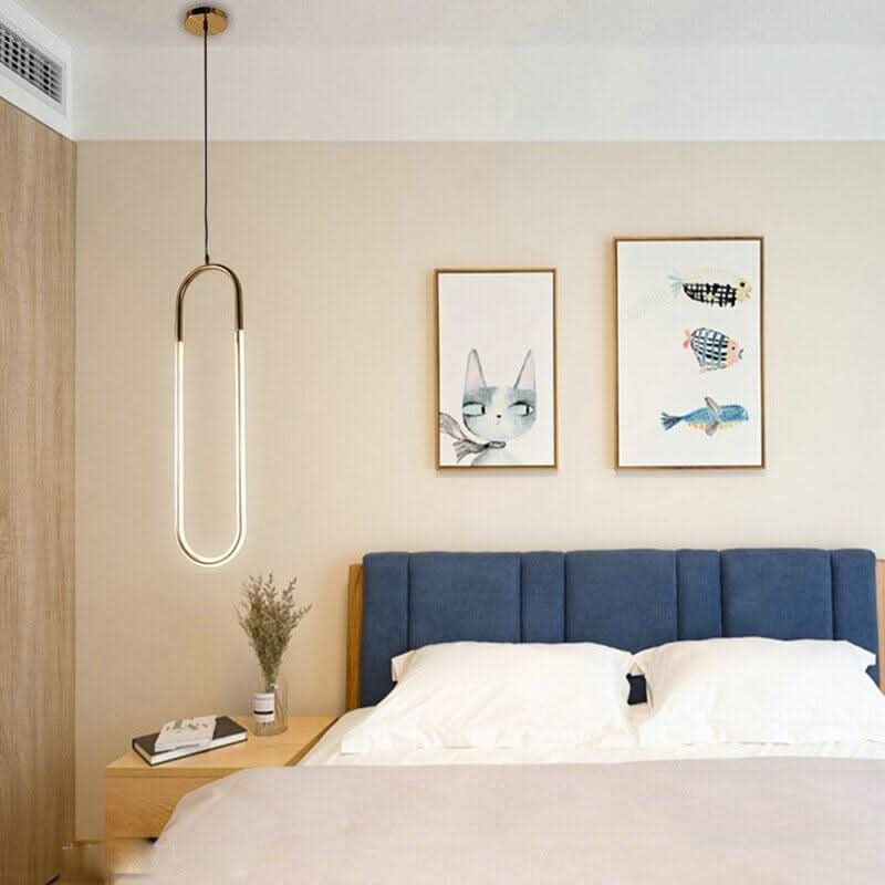 Suspension tubulaire éclairée au-dessus d'une table de nuit, chambre bleue.