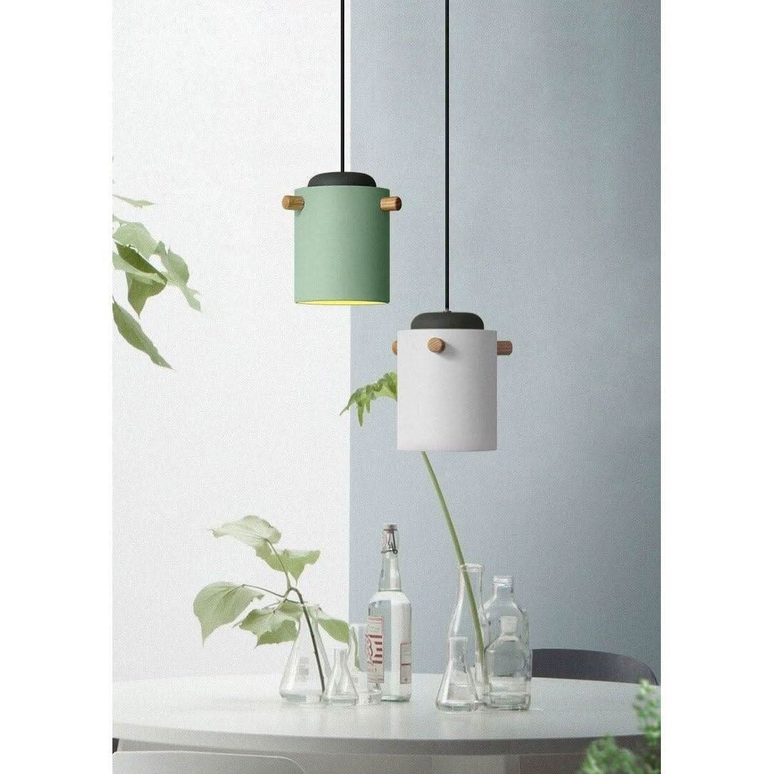 Deux suspensions verte et blanche au-dessus d'une table avec bouteilles et plantes