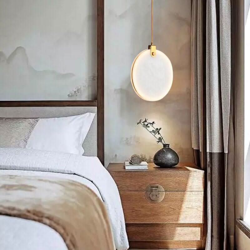 Suspension boule lumineuse suspendue près d'un lit avec table de chevet en bois