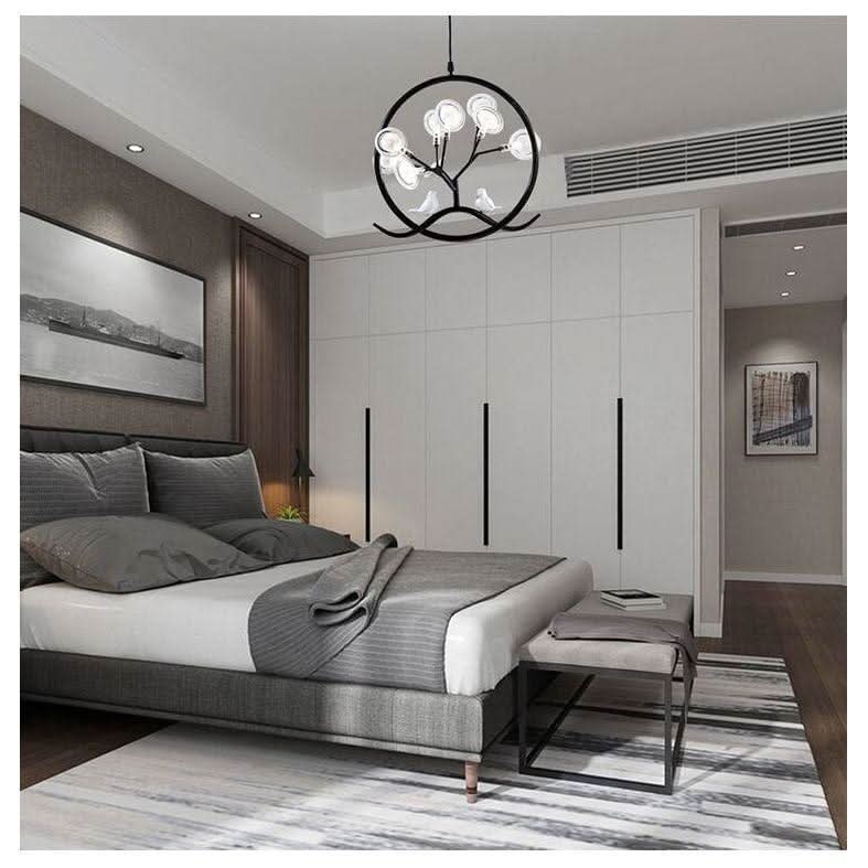 Suspension noire installée dans une chambre, au-dessus d'un lit gris et blanc.