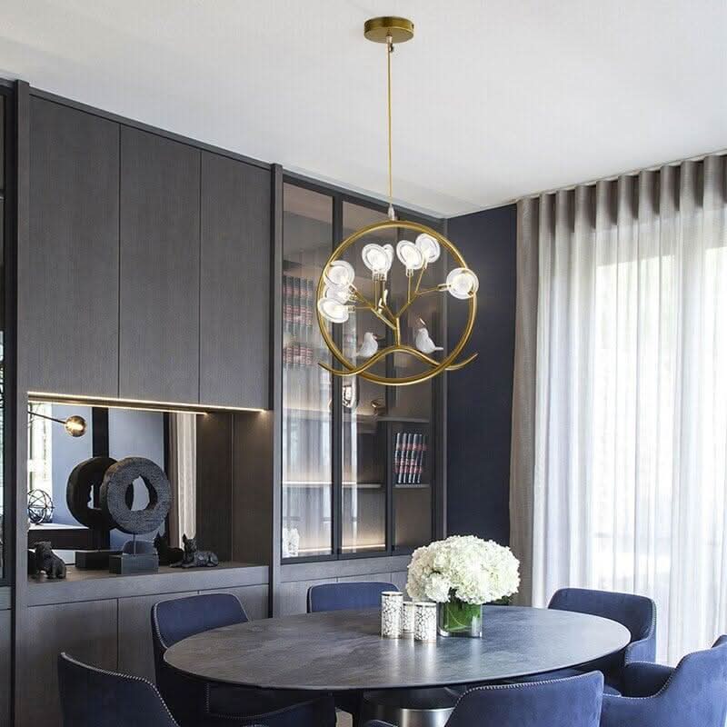 Luminaire doré suspendu dans une salle à manger moderne avec meubles gris.